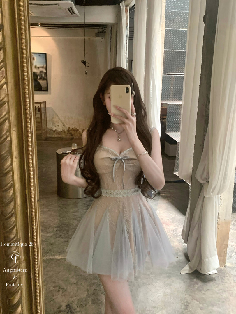 Model wearing a sheer lace dress in a mirror selfie