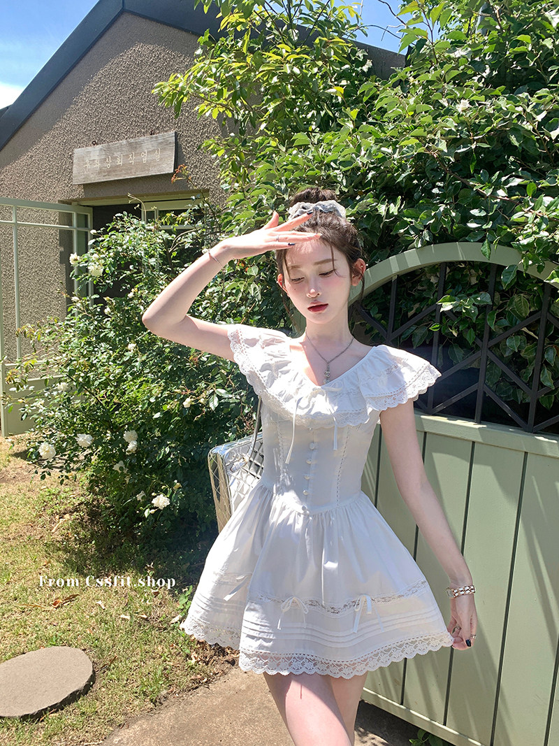 White lace short dress worn by a model outdoors in sunlight