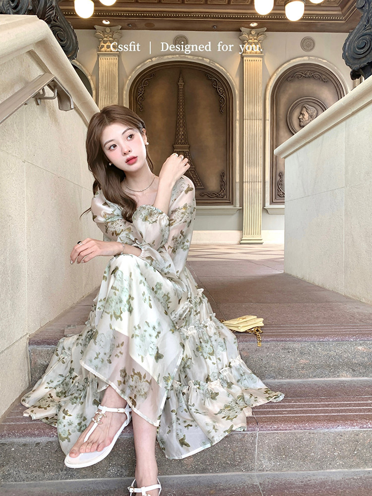 Woman wearing a light floral long dress on outdoor steps