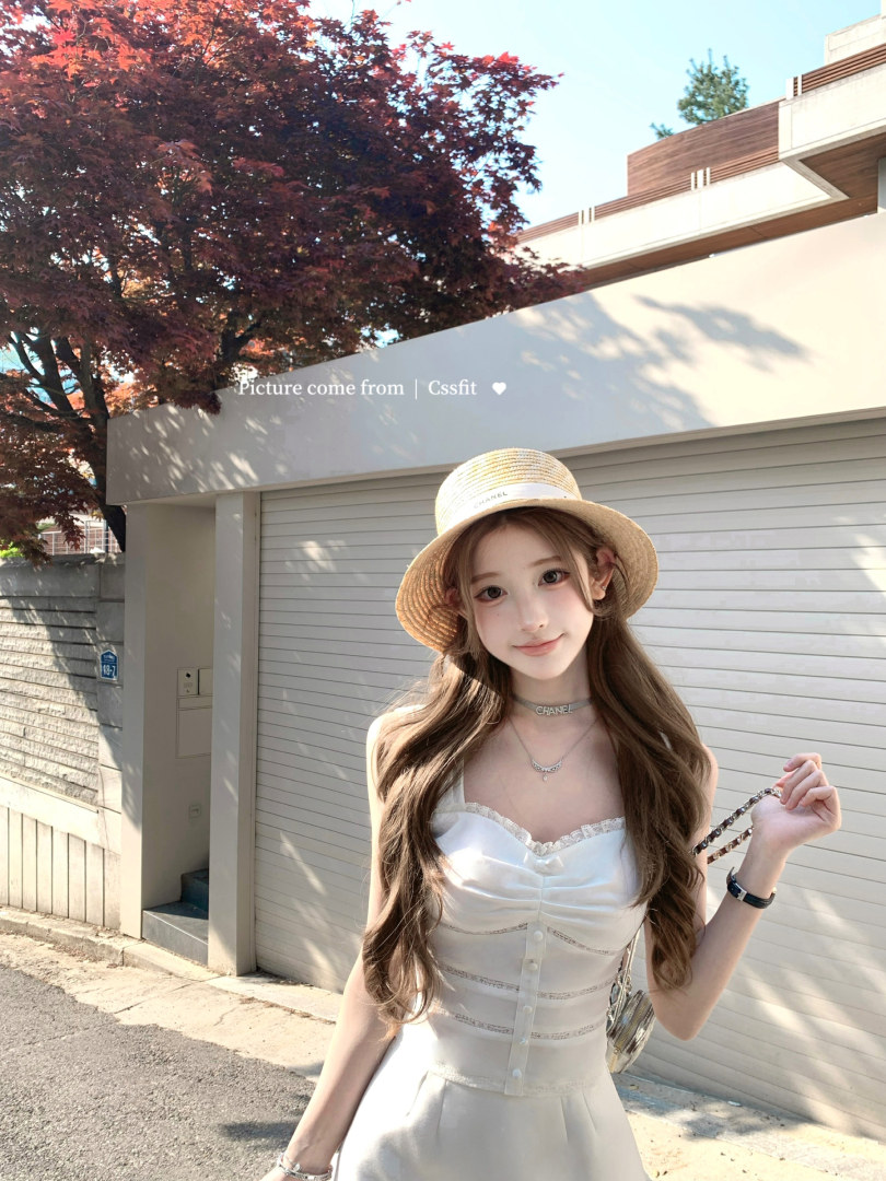 Woman wearing a white dress and straw hat outdoors