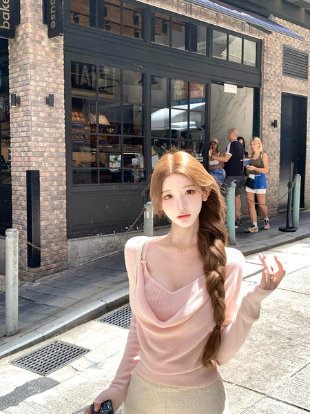 Woman wearing a light pink ribbed long-sleeve top outdoors