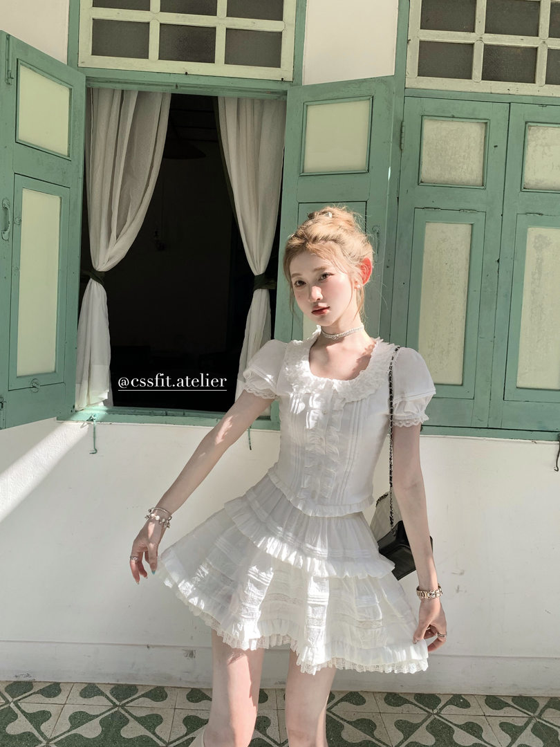 Model wearing a white ruffled short dress outdoors