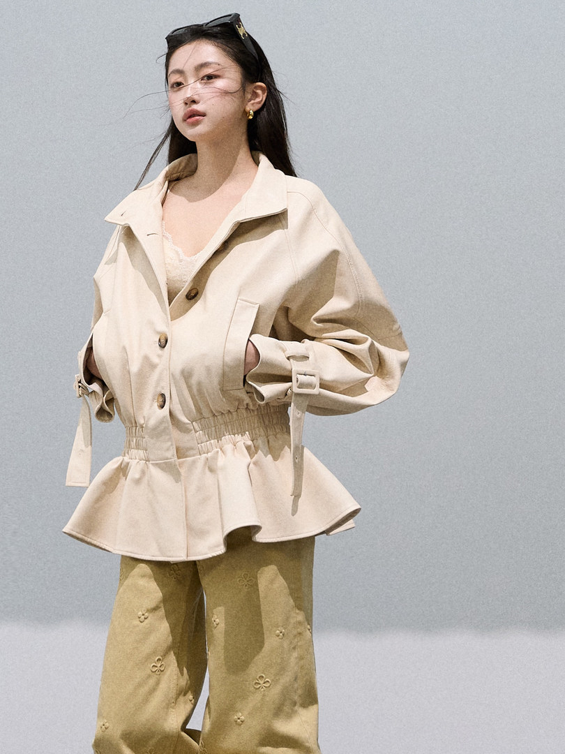 Woman wearing a beige belted jacket with matching wide-leg pants