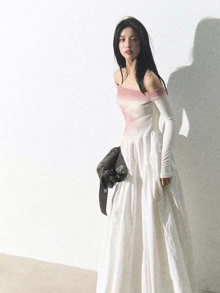 Model wearing a white off-shoulder long dress with pink gradient detail