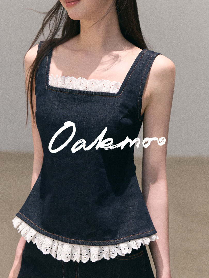 Model wearing a dark denim sleeveless top with white lace trim