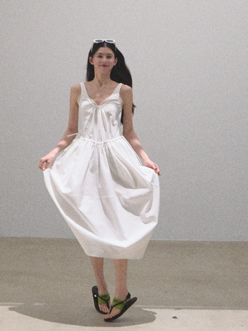Model wearing a white sleeveless midi dress