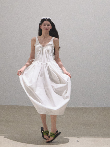 Model wearing a white sleeveless midi dress