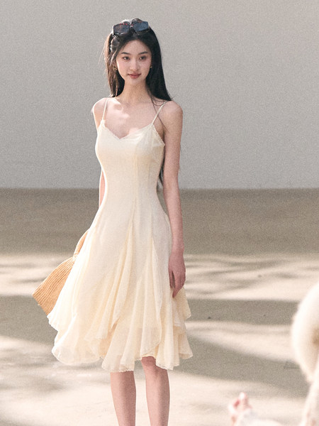 Woman wearing a light cream sleeveless dress outdoors