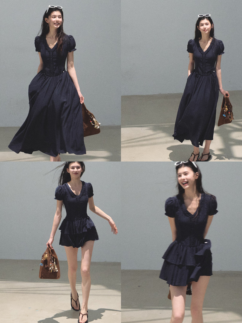 Model wearing a navy puff-sleeve dress with a fitted corset-style bodice