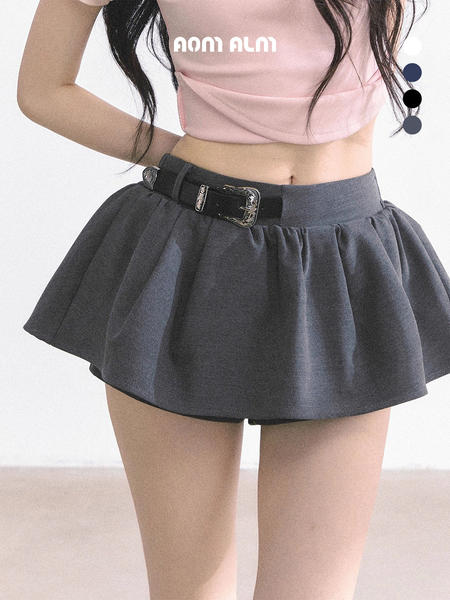 Model wearing a dark pleated mini skirt with belt and pink crop top