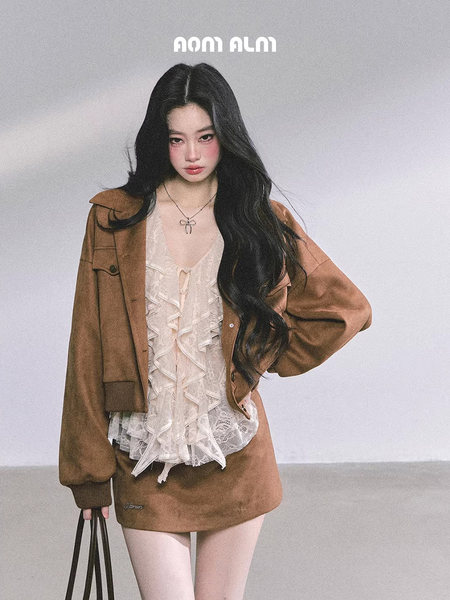 Model wearing a brown layered outfit with a lace top and jacket