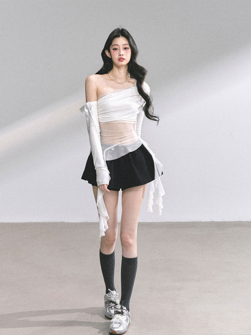 Model wearing a white off-shoulder layered top with a black mini skirt, knee-high socks, and silver sneakers