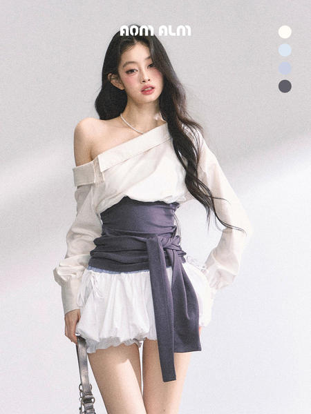 Model wearing a white off-shoulder blouse with a dark wrap waist and white shorts