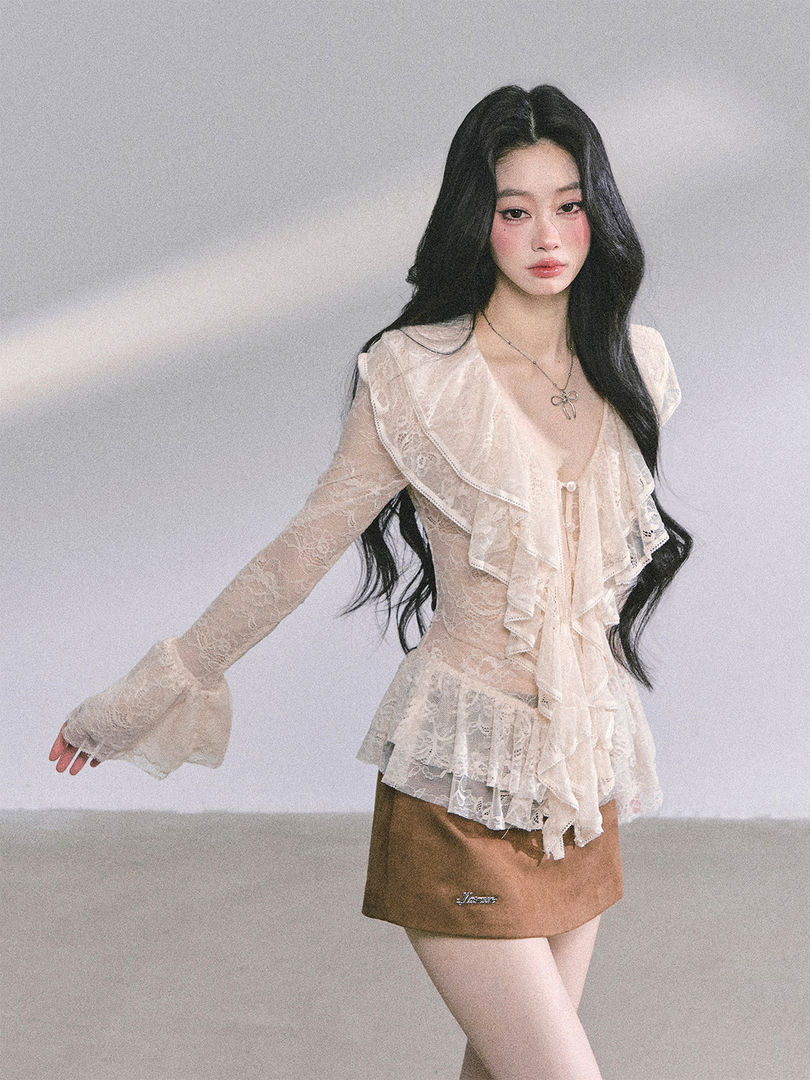 Model wearing a sheer lace ruffled blouse and mini skirt