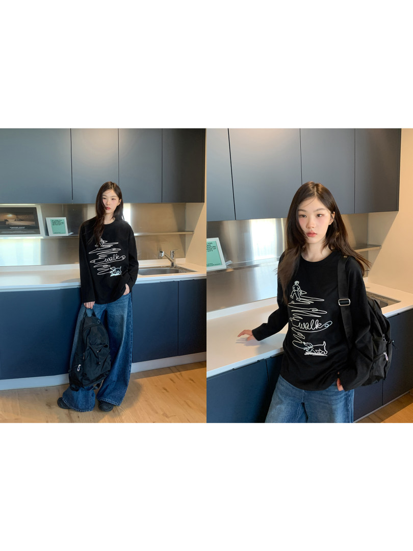 Black long-sleeve graphic sweatshirt worn by a model with blue jeans