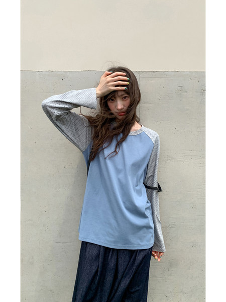Model wearing a light blue and gray long-sleeve top