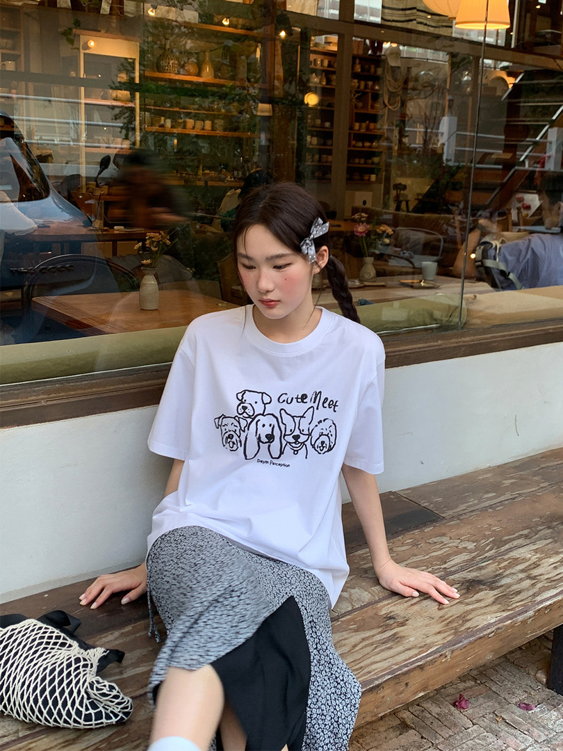 White graphic dog-print T-shirt worn with a patterned skirt