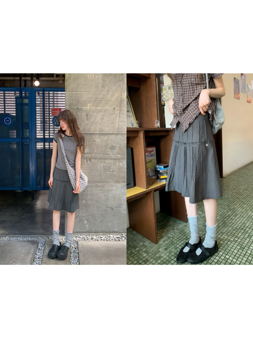Grey pleated midi skirt worn by a model in casual street-style outfits