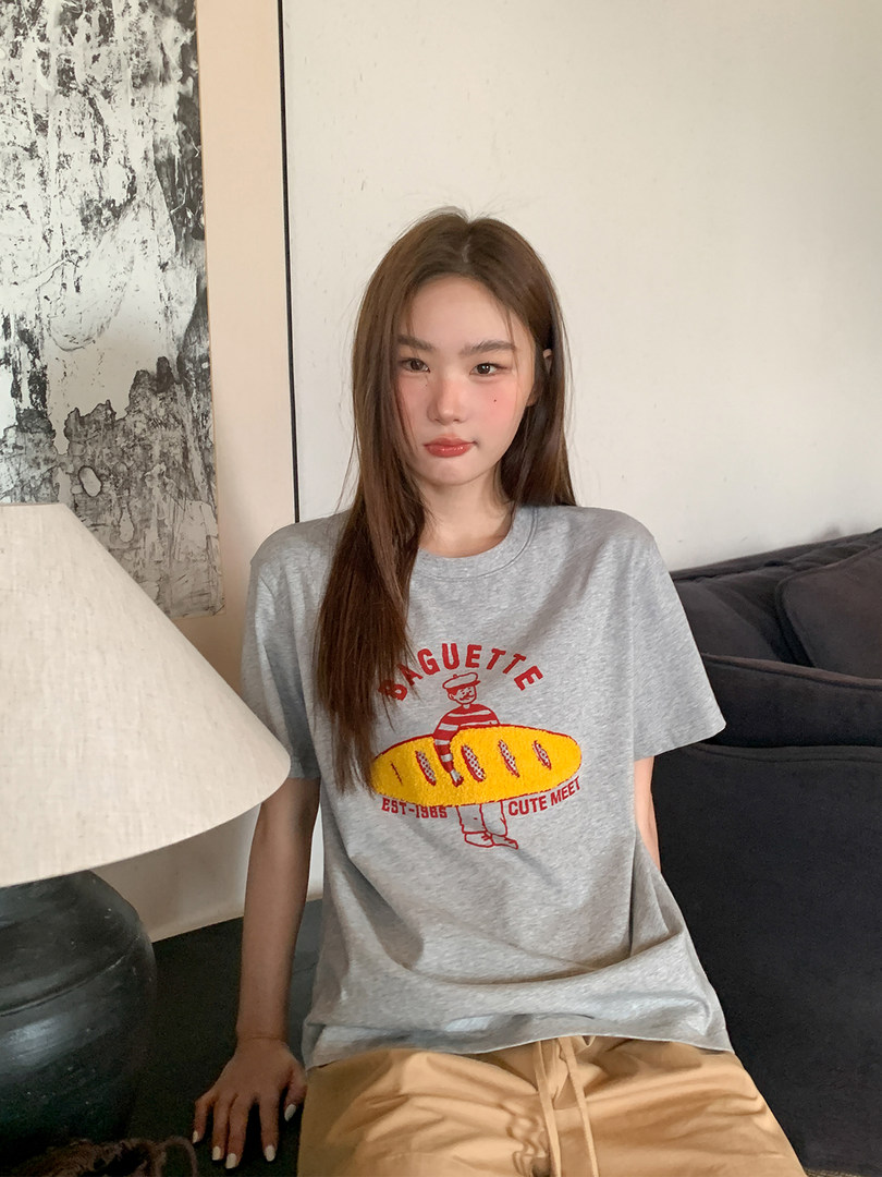 Grey graphic oversized T-shirt worn by a model indoors
