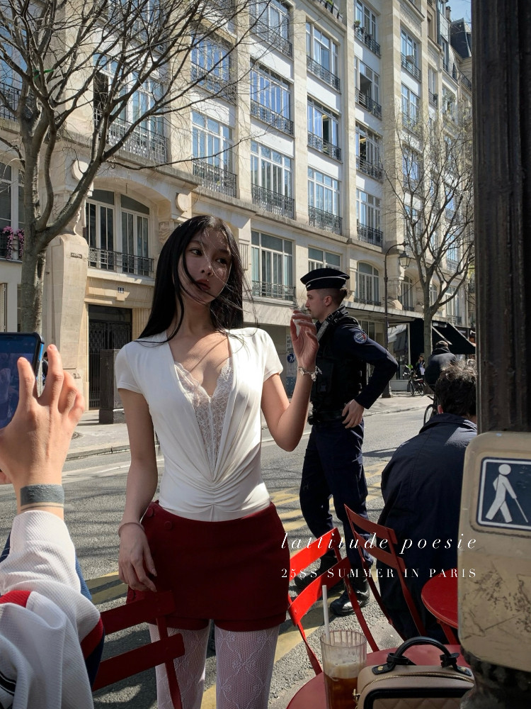 Woman wearing a white deep-V top and red shorts on a Paris street