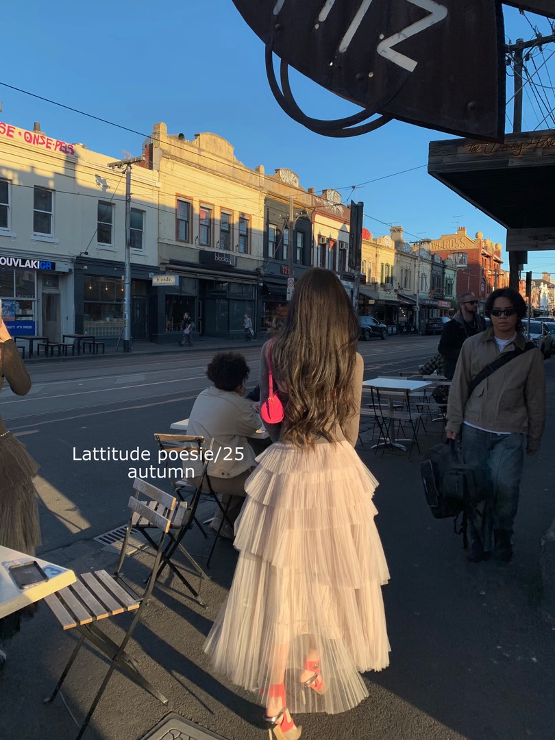Woman wearing a cream pleated tulle dress on a city street