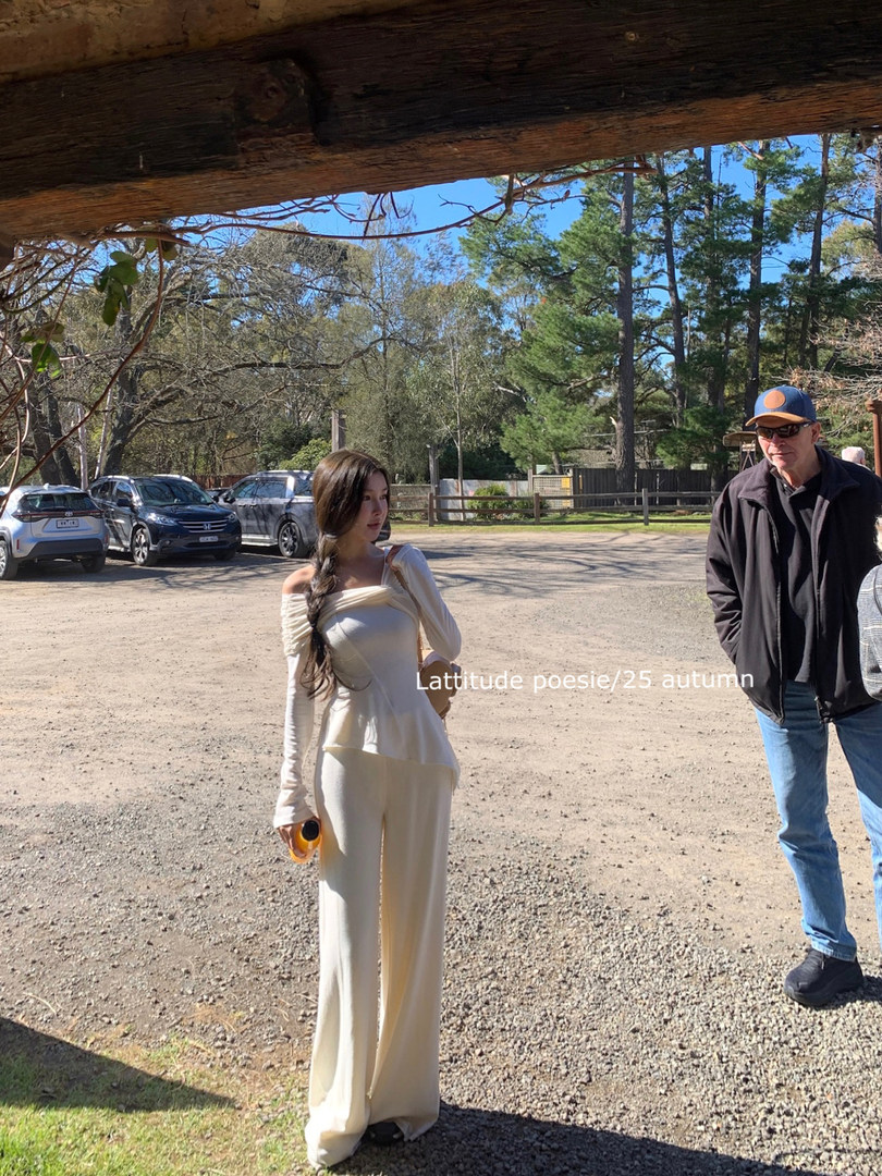 Woman wearing a cream off-shoulder two-piece outfit outdoors