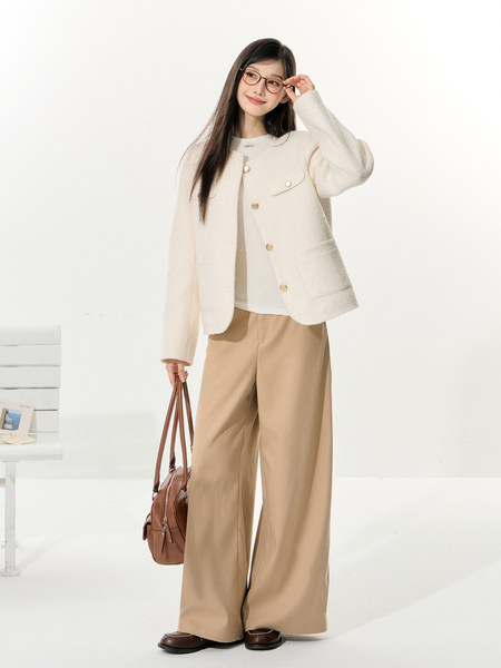 Model wearing a cream buttoned jacket, beige wide-leg trousers, and brown handbag