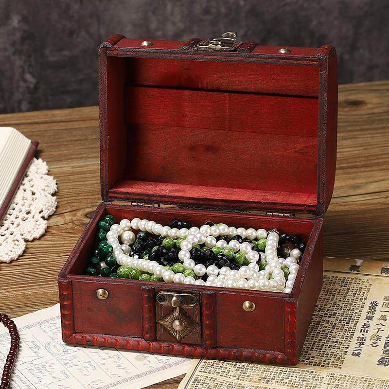 An old wooden box table containing a box of jewellery and a