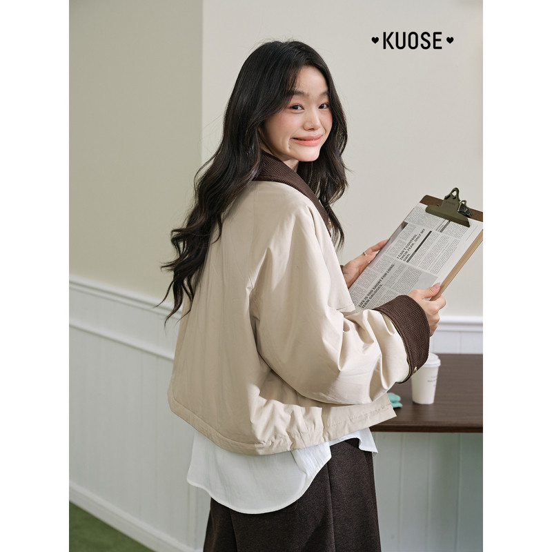Model wearing a beige cropped jacket over a white top