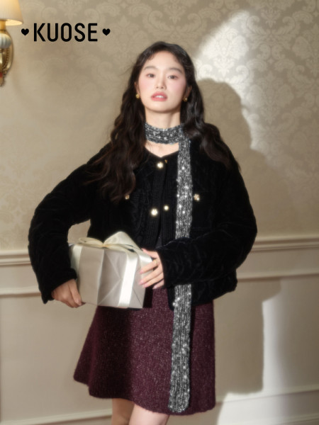 Woman modeling a black jacket with a sparkly scarf and burgundy skirt