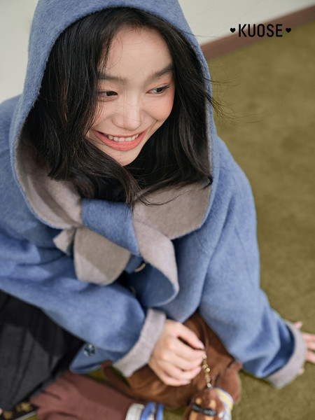Woman wearing a blue hooded coat with a soft, cozy look