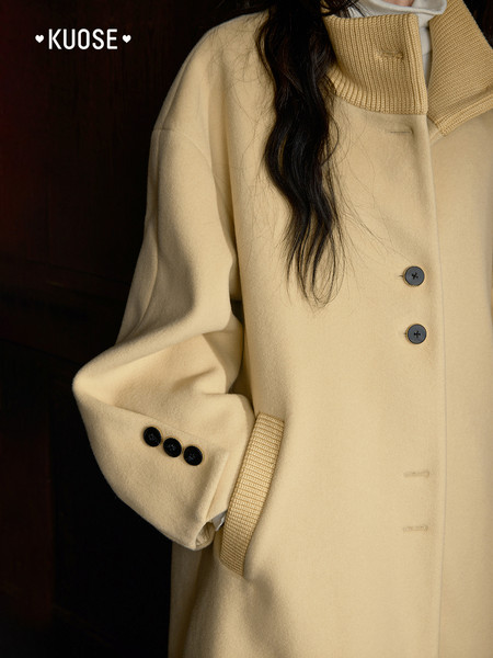 Beige wool coat worn by a model with button details
