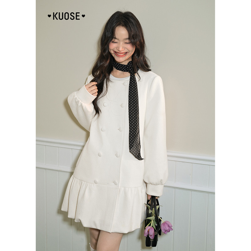 Model wearing a white long-sleeve dress with a black polka-dot scarf