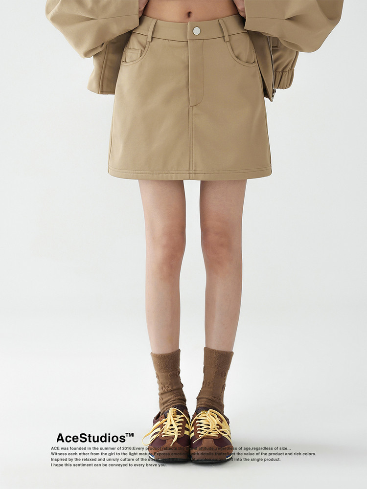 Tan mini skirt worn by a model with sneakers and socks