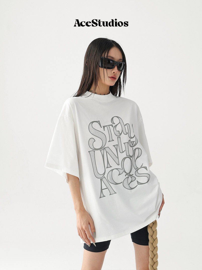 Model wearing a white oversized graphic T-shirt with printed text