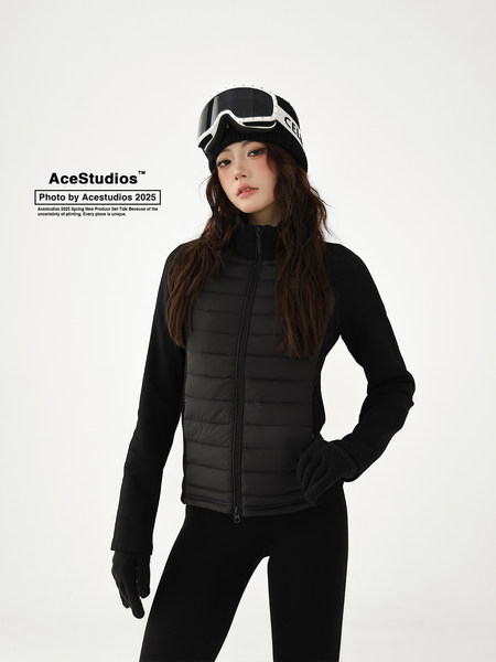 Black quilted zip-up winter jacket worn by a model with ski goggles and gloves