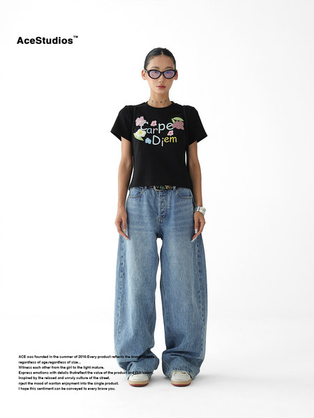 Model wearing a black graphic T-shirt and oversized blue jeans