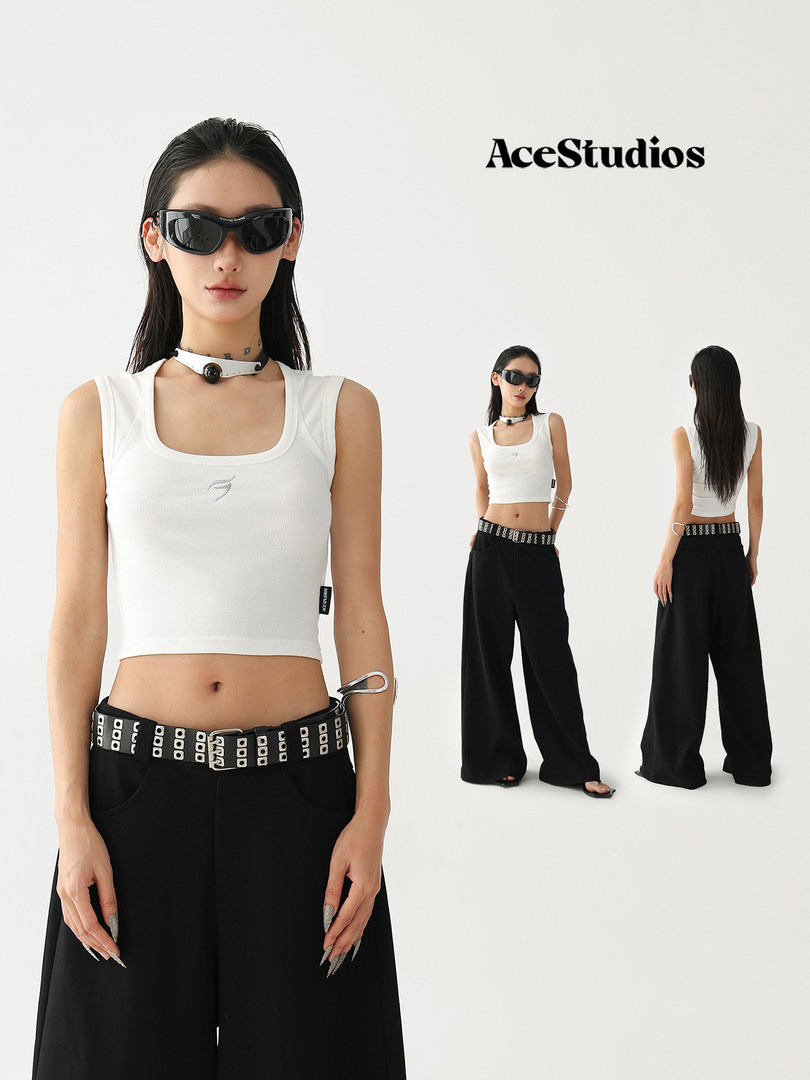 Model wearing a white crop top with black wide-leg pants and sunglasses