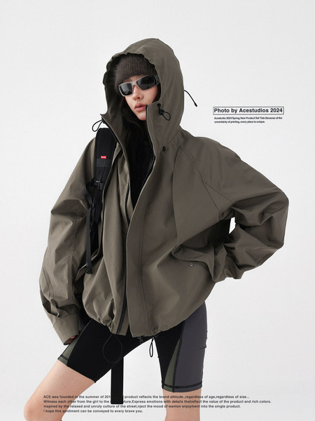 Model wearing an oversized olive hooded jacket with black shorts
