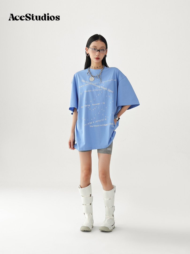 Model wearing a blue oversized graphic T-shirt with white boots