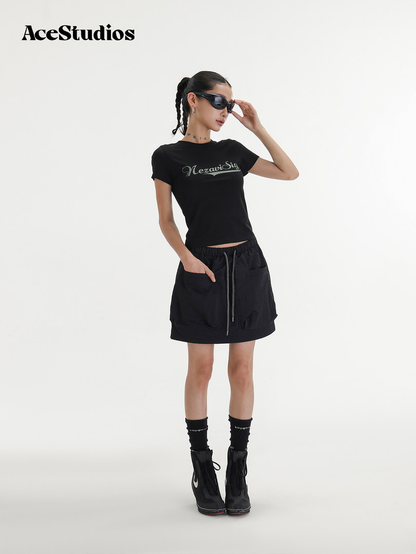 Black short-sleeve tee and mini skirt outfit worn by a model