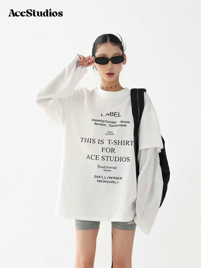Model wearing an oversized white graphic T-shirt with black sunglasses
