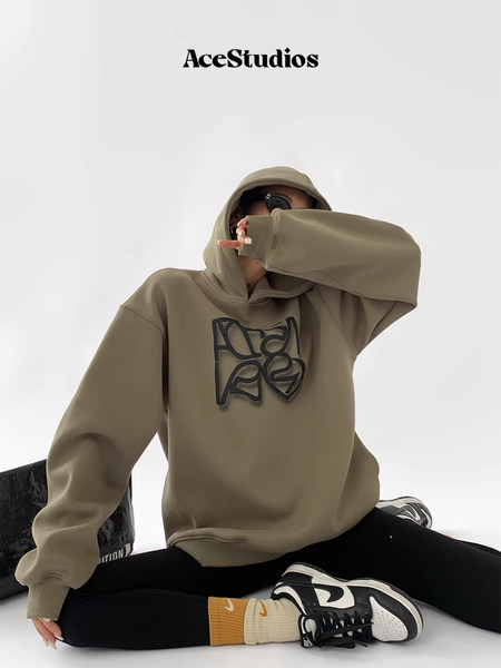 Model wearing an oversized khaki hoodie with graphic print
