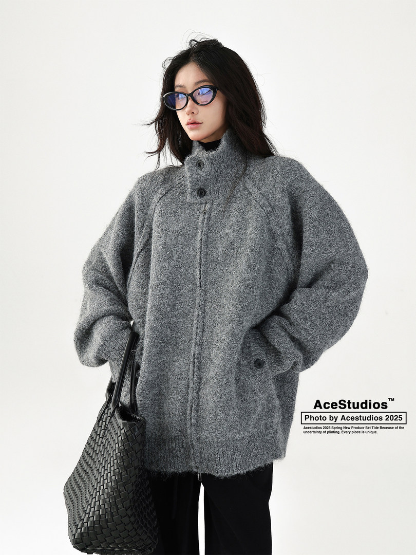 Model wearing a gray oversized fuzzy coat with a woven black bag