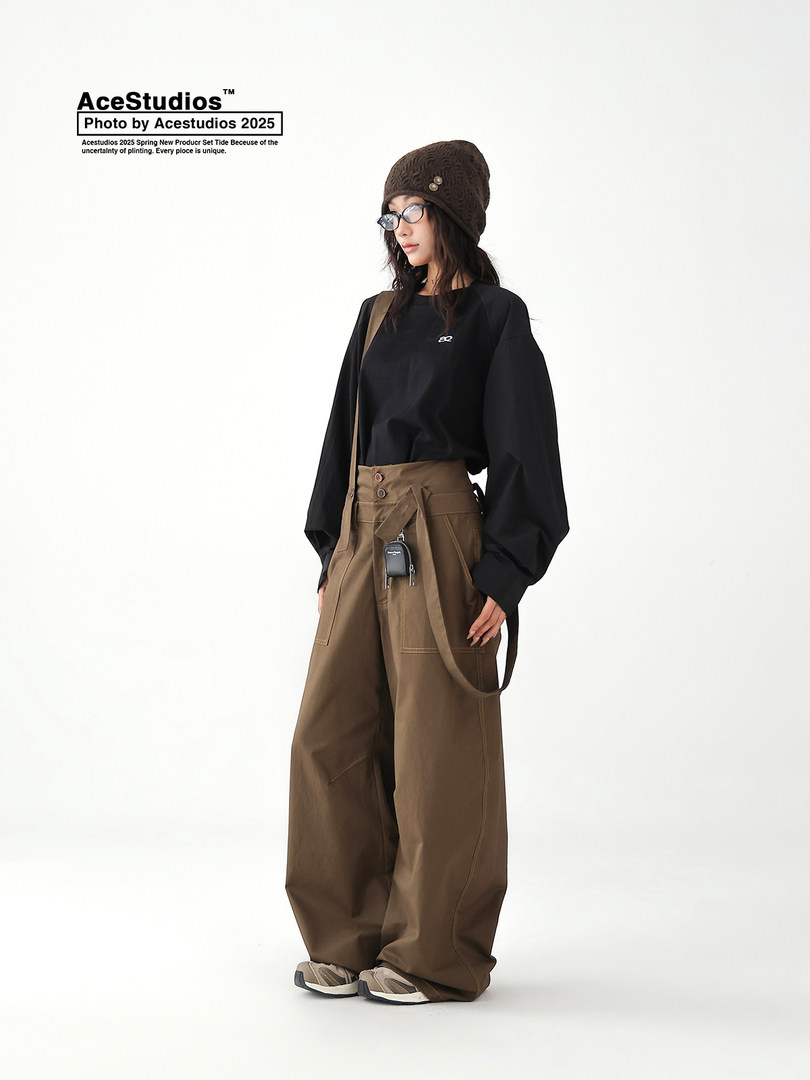 Fashion model wearing a black long-sleeve top and oversized brown wide-leg pants
