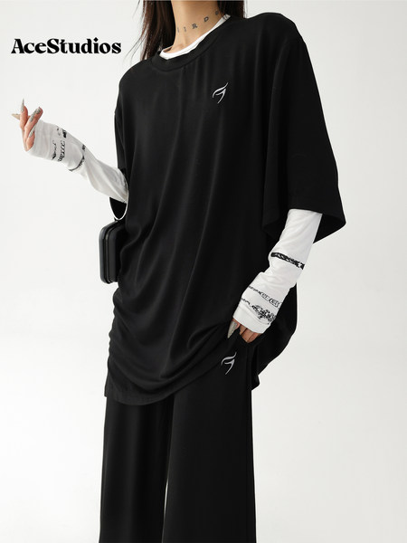 Black oversized streetwear outfit worn over white long sleeves