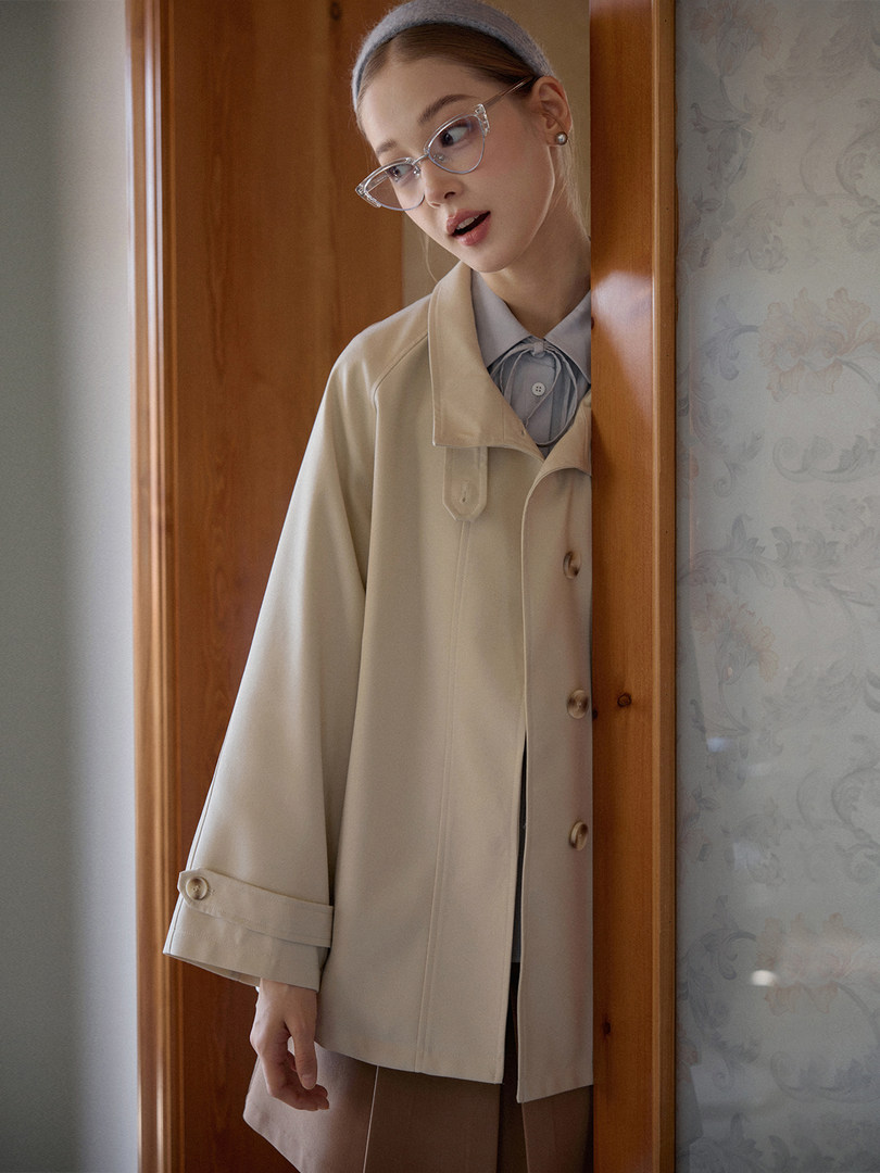 Beige lightweight coat worn by a model indoors