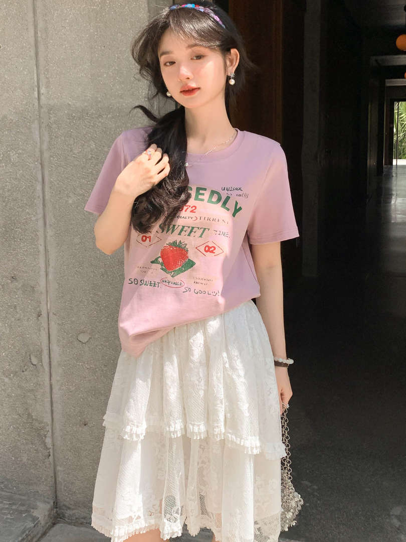 Model wearing a pink graphic T-shirt with a white lace skirt