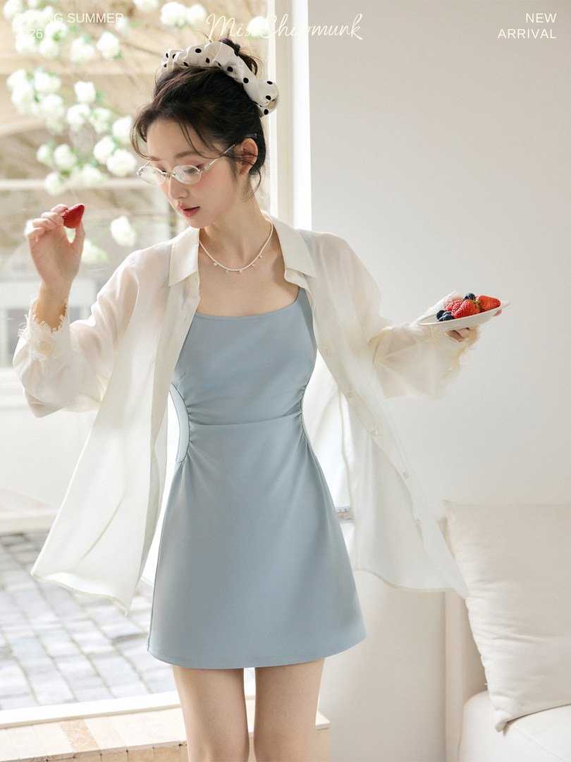 Model wearing a light blue sleeveless mini dress with a sheer white overshirt