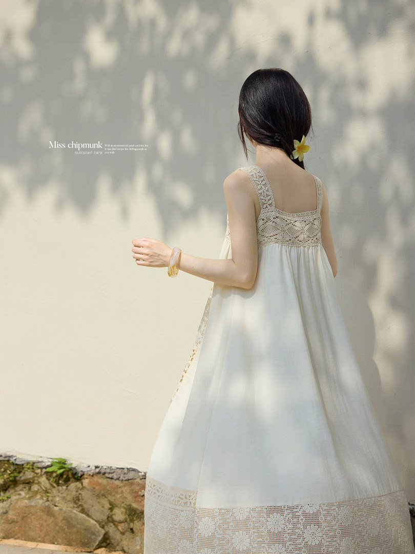 Woman wearing a white sleeveless lace maxi dress outdoors